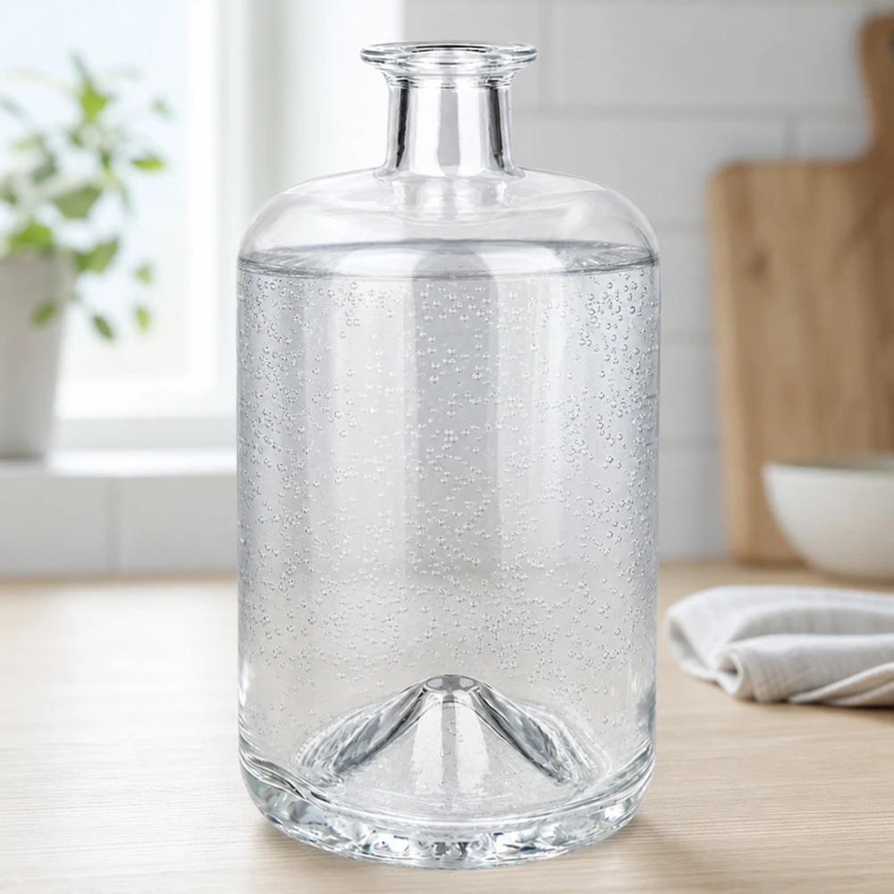 700 ml apothekersfles Sofia zonder sluiting UNiTWIST® 700 ml Sofia-glasfles gevuld met sprankelend water toont koolzuurbubbels in een heldere keukenomgeving