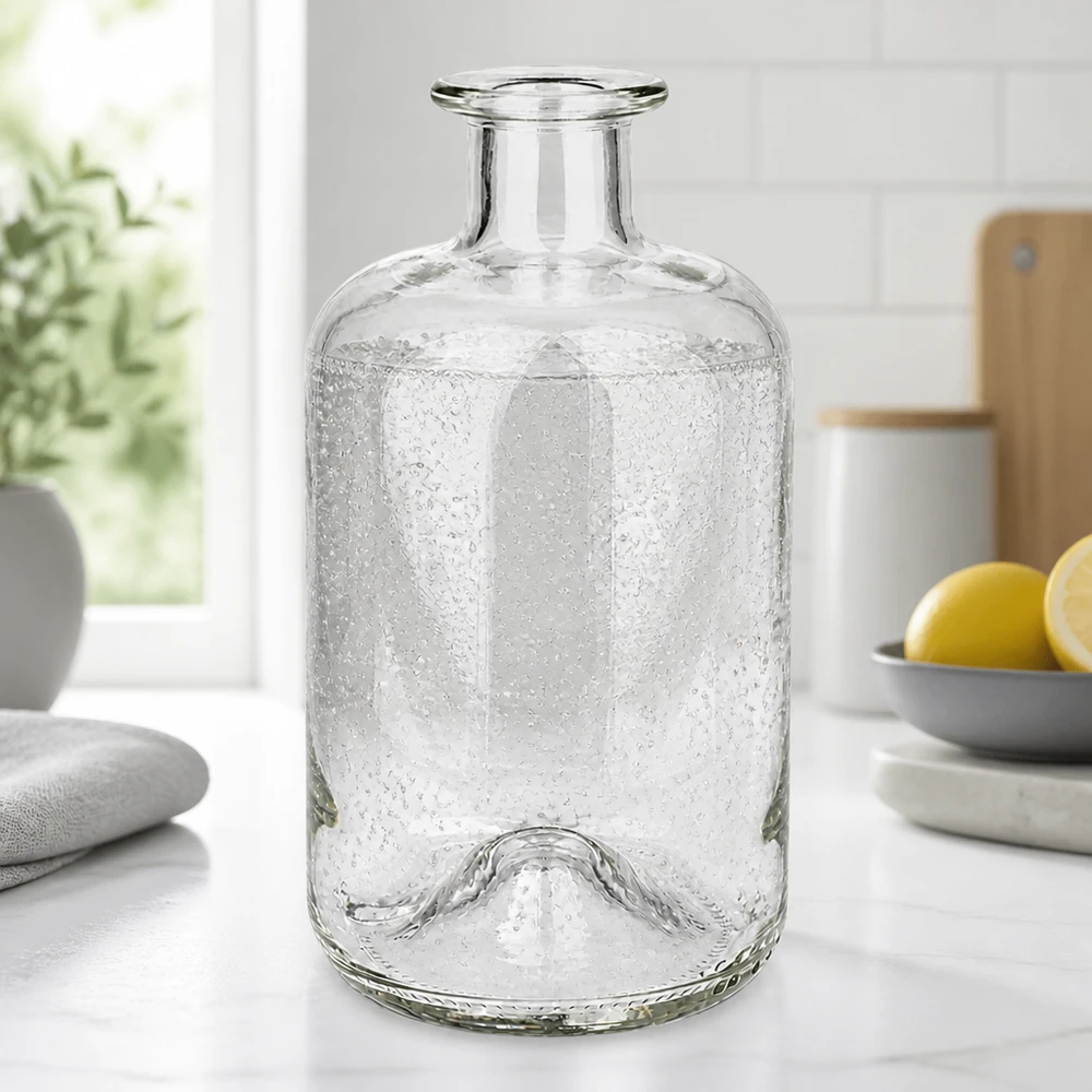 500 ml Apothekersfles 500ml Glasflasche "Luna" ohne Verschluss UNiTWIST zonder sluiting UNiTWIST® Apothekersfles Luna 500ml met bellenstructuur op een wit keukenblad naast citroenen en planten
