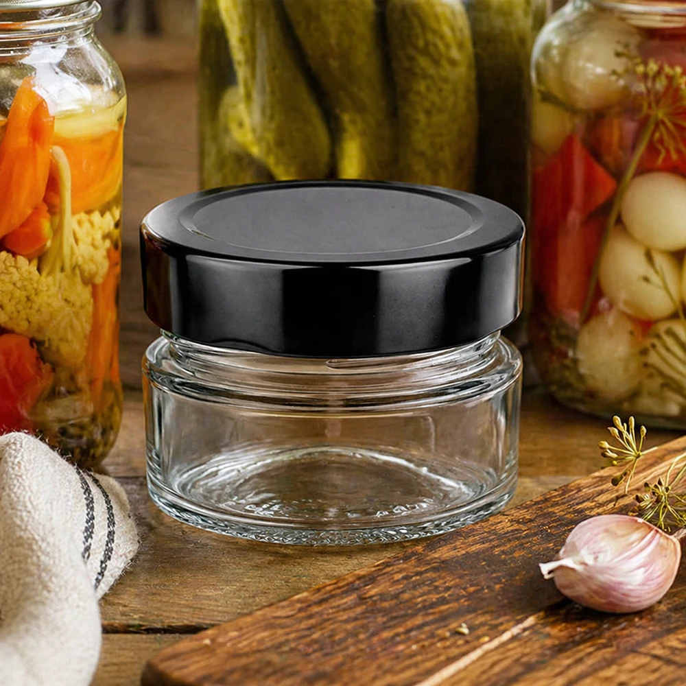 80ml rond glas met BasicSeal deksel zwart deep UNiTWIST 80ml ronde pot BasicSeal zwart UNiTWIST keukenscène inmaakpotten houten plank knoflook dille conservering
