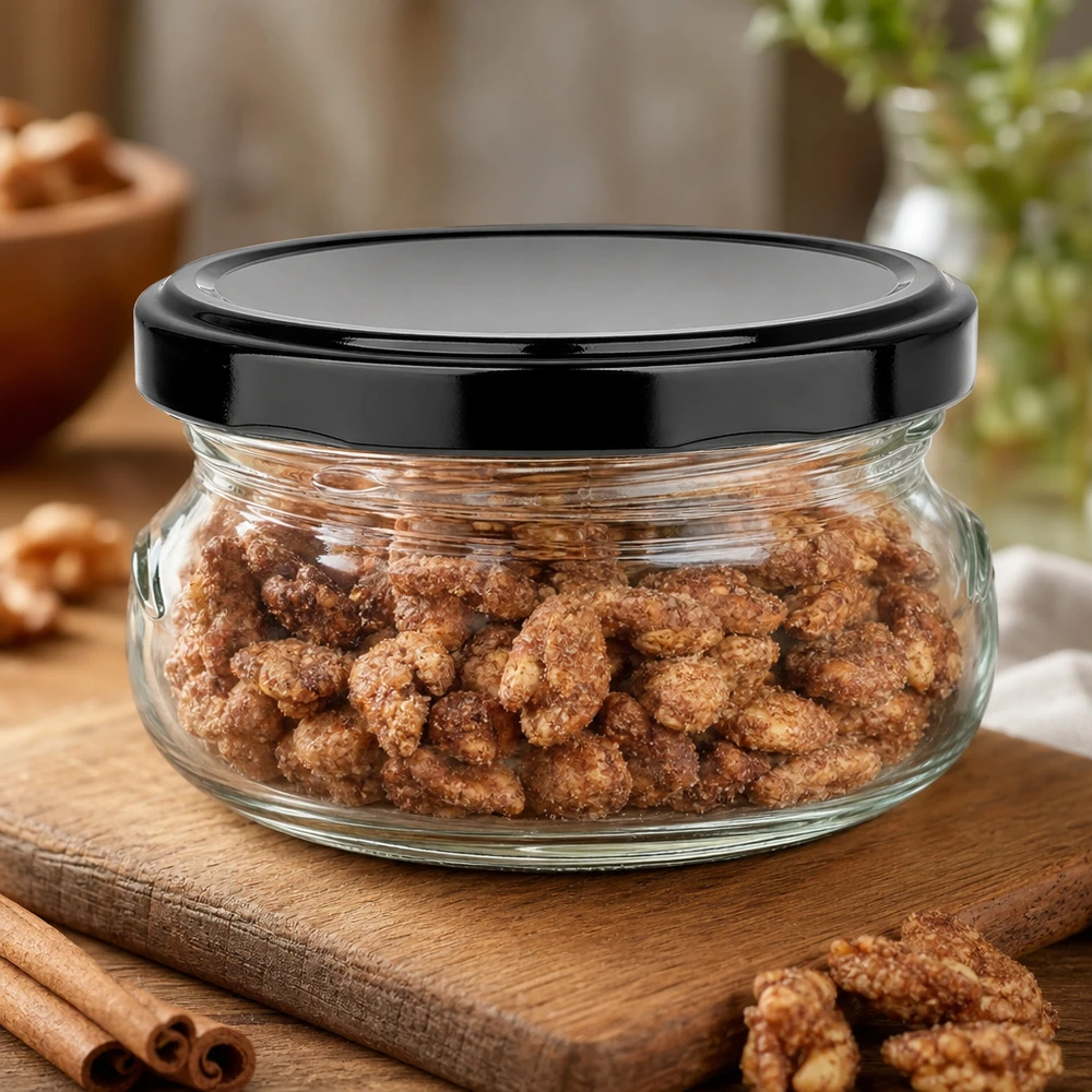 120 ml terrinepotje gevuld met geroosterde noten, zwart deksel, kaneelversiering op een rustiek houten plankje