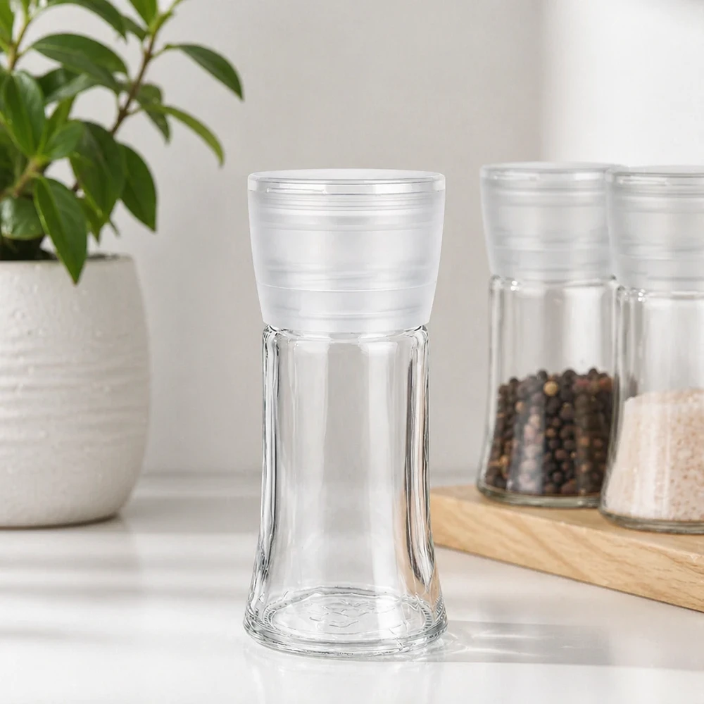 Zout-/kruidenpotje 95 ml met molen Vario wit Leeg kruidenpotje van 95 ml met witte Vario-molen naast peperkorrels en zout op een houten plankje