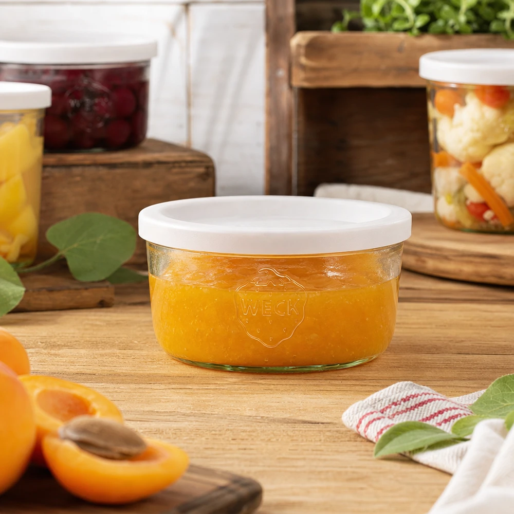 WECK 165ml mason jar gevuld met sinaasappeljam in een natuurlijke keukenomgeving met inmaakpotten op de achtergrond