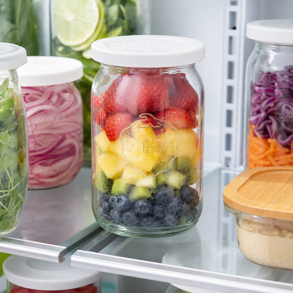 145ml cilinderglas met vershouddeksel WECK RR40 WECK RR40 cilindrische pot 145ml gevuld met fruit in de koelkast voor maaltijdbereiding met bessen en kiwi's