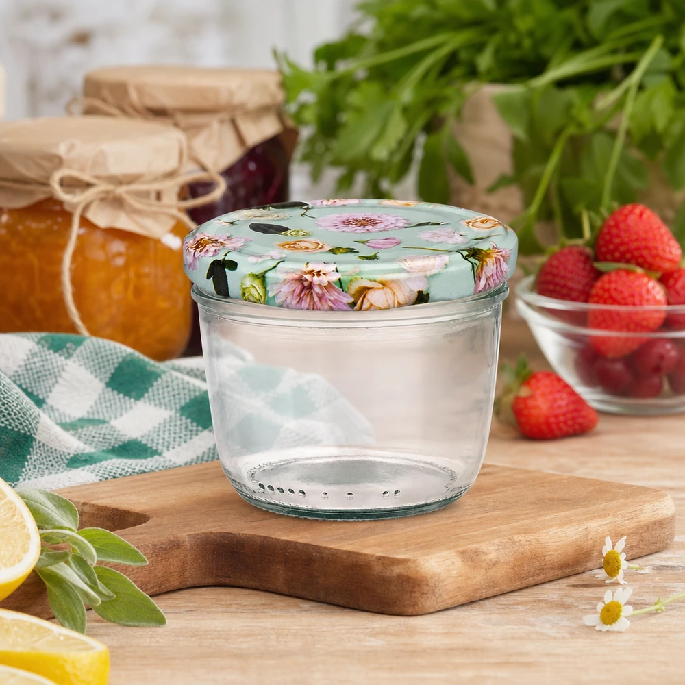 230ml bekers met gebloemde BasicSeal deksel op houten plank, keukentafereel met jam, aardbeien en kruiden